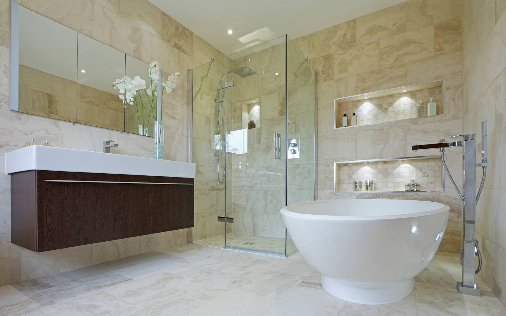 Luxury bathroom with stone tiles, freestanding tub, and walk-in shower